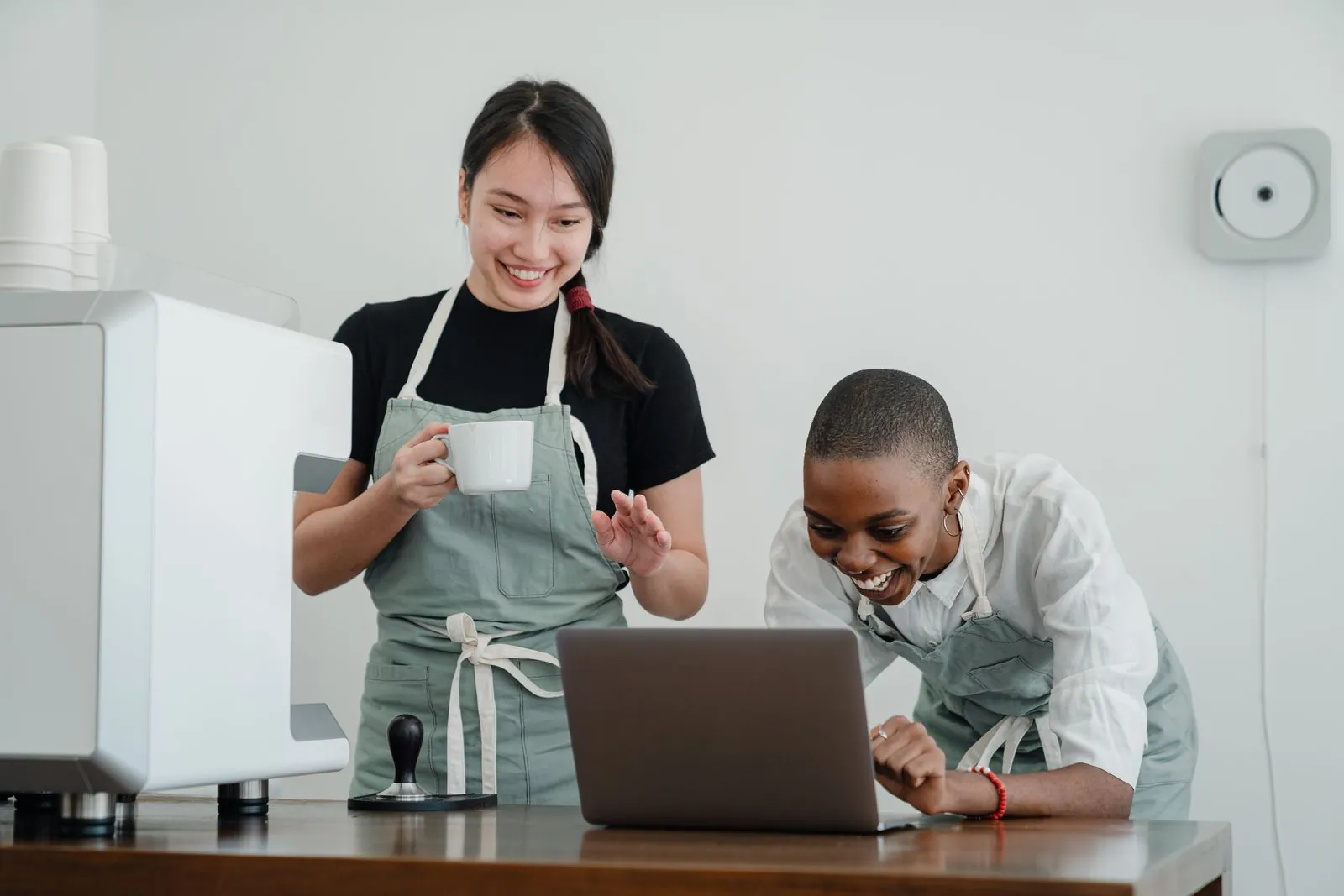 Dos profesionales de una cafetería revisan juntas una computadora