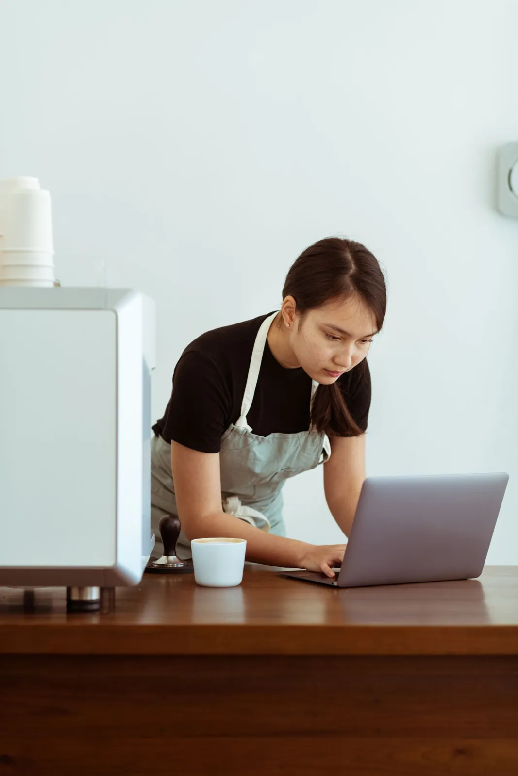 Profesional de una cafetería trabaja en su computadora
