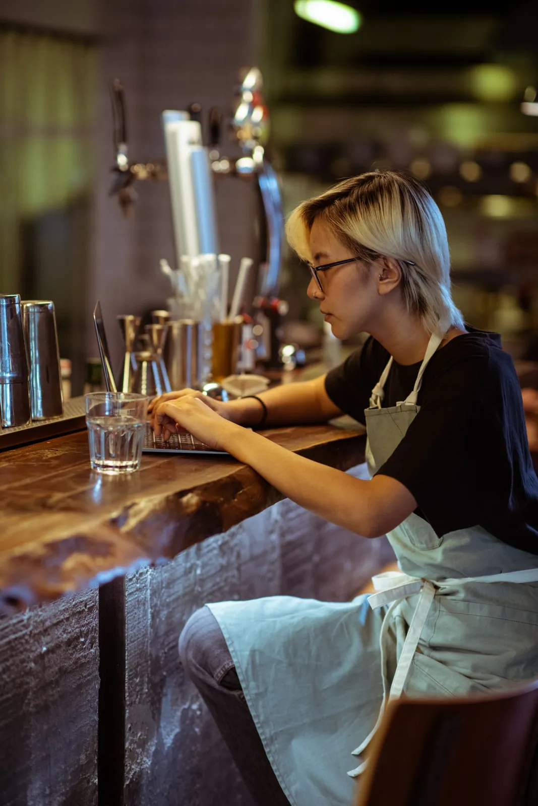 Profesional de una cafetería gestiona información desde su computadora