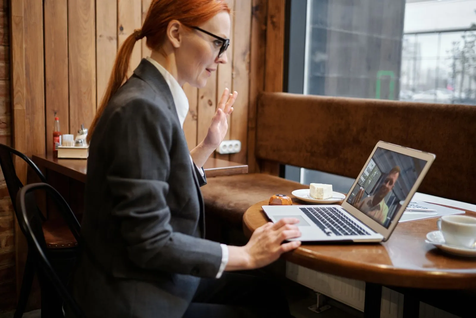 Profesional saluda durante una reunión virtual